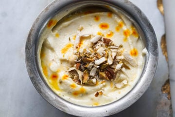 Shrikhand topped with chopped nuts in a small bowl.