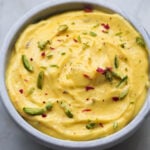 Greek yogurt shrikand topped with pistachios and rose petals.