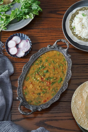 Dal palak (spinach dal) served with rice, salad and papad