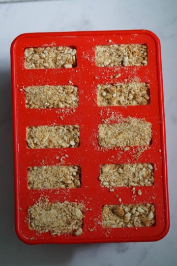 mango cheese cake popsicles with cookie crumbles as a crust in mold.