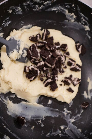 Oreo cookies added to cookies and cream burfi mix in pan.