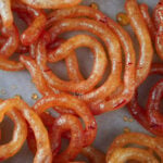 Orange jalebis on parchment paper
