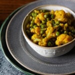 gobi matar or cauliflower shaak in a bowl on a gray plate.