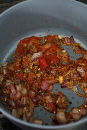 chole spices cooking in a non-stick pan.