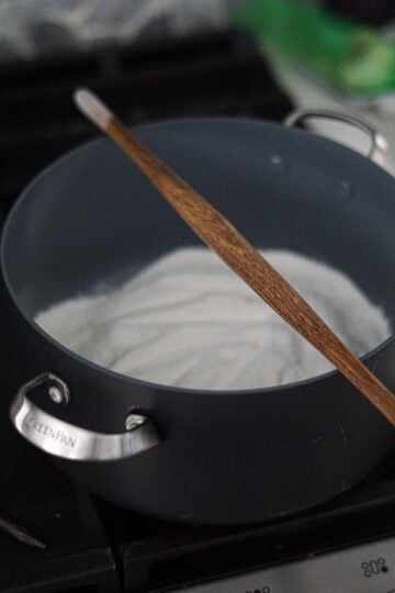 velan for khichu on top of a rice flour filled pot.