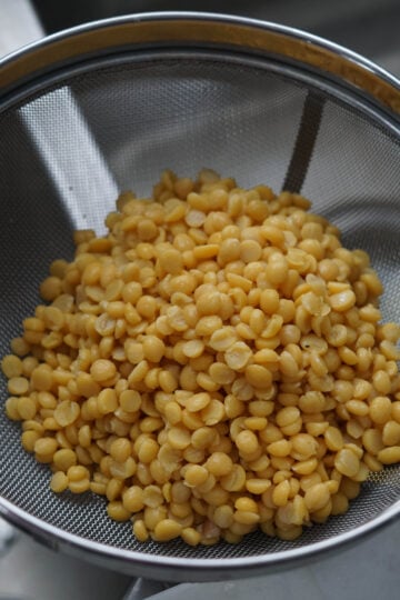 Washed chana dal in a colander.