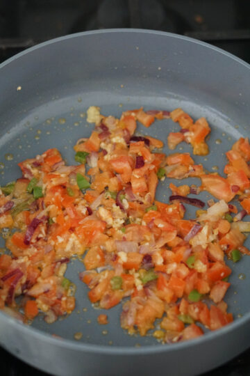 Tomatoes, jalapenos, onions, garlic in a pan heated with oil.