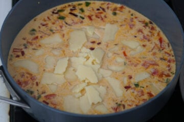 Cheese and evaporated milk with sauteed veggies add into pan.