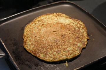 Flipped pudla showing cooked brown side.