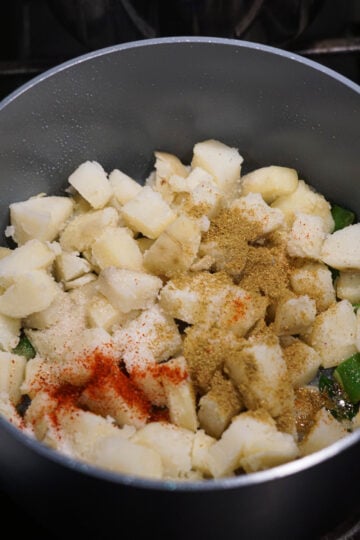 Boiled, cut potatoes added to pot with spices.