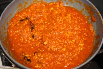 Add crushed garlic and tomatoes to pan.