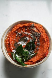 Tadka poured on top of garlic tomato chutney.