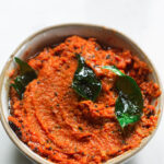 Garlic Tomato Chutney in a bowl with curry leaves on top