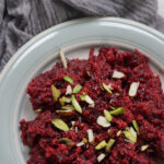 beetroot halwa on a plate with pistachios garnished on top