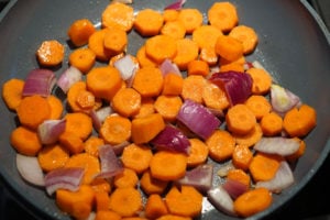 Carrots and onion cooking in a pan