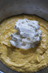 Whipped cream added to mango cheesecake mixture