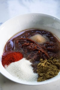 Apple butter and spices in a white bowl.