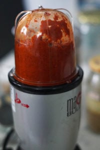 Garlic chutney ingredients being blended in a blender.