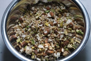 Roasted and ground cashews, pistachios, walnuts and almonds roughly chopped in a steel bowl.