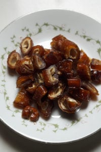 Chopped dates in a leaf vine designed white plate.