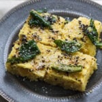Khaman with tadka poured on top and dessicated coconut.