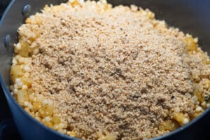 Ground roasted peanuts added to pan