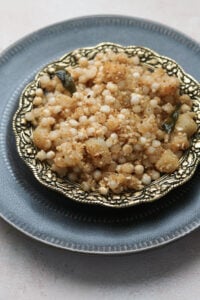 Sabudana khichdi in an ornate gold bowl on a gray plate.