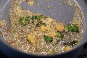 Spices in a pan cooking in oil.
