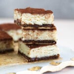 Tiramisu barfi bars stacked on top of each other.