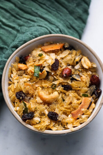 Poha chevdo in a bowl with peanuts, cashews and raisins.