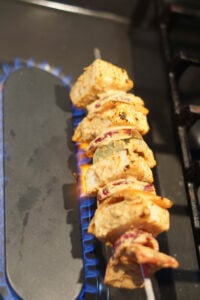 Grilling paneer tikka on stovetop flame on gas stove.