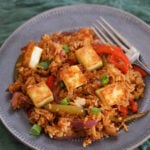 Chilli paneer fried rice on a gray plate with a fork to the side.