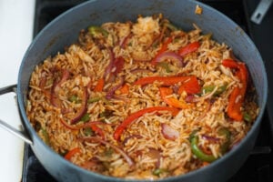 Rice added to pan with vegetables and spices.