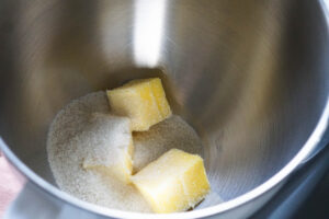 Butter cubes and sugar in mixing bowl.