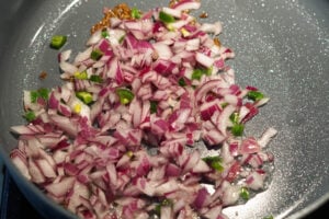 Onions and green chillies added to pan.