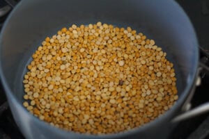 Chana dal roasting in a gray nonstick pan.