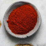 Kashmiri chili powder in a gray bowl.