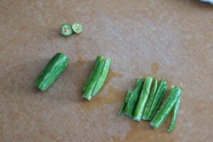 Cut tindora or ivy gourd on a cutting board.