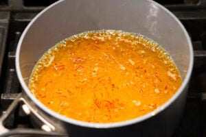 Saffron simple syrup on stovetop in a pot.