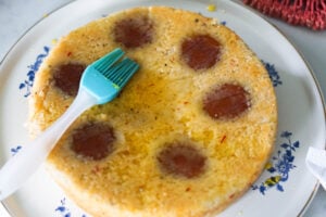 Brushing gulab jamun cake with simple syrup.