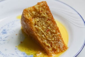 Slice of gulab jamun cake with saffron simple syrup.