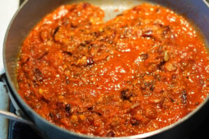 Crushed tomatoes added to pan.