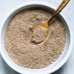 Chaat masala powder in a bowl with a gold spoon.