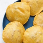 Fluffy masala puris on a blue plate.