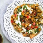 Prepared samosa chaat in a white lace trim plate.