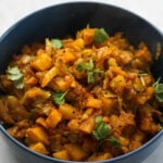 Cabbage shaak in a blue bowl with cilantro garnish.