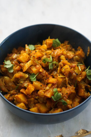 Cabbage shaak in a blue bowl with cilantro garnish.