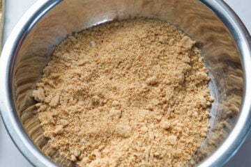 Ground roasted peanuts in a steel bowl.