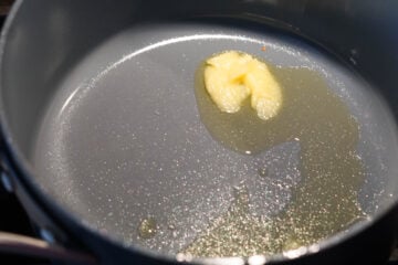 Ghee melting in a pan on the stovetop.