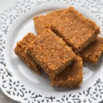 Sing pak or peanut burfi squares on a white laced plate.